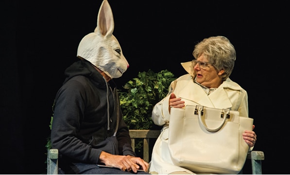 Man in a rabbit mask and a woman with a handbag